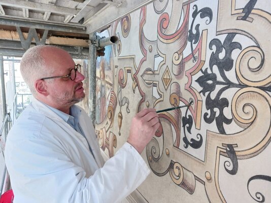 Der Restaurator: Rolf Zurfluh retuschiert die Wandmalerei am Bürgerasyl. sb